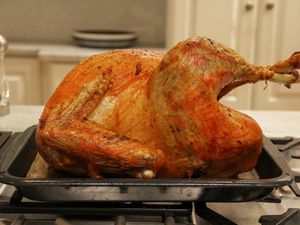 A cooked Grassland Beef Pasture Raised Turkey cools on a baking pan.