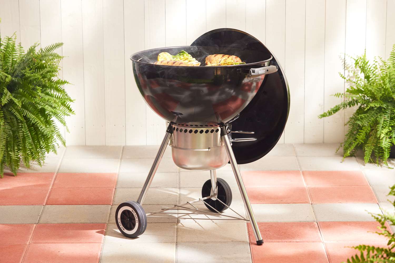 a charcoal grill cooking food on a patio