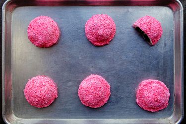 Overhead view of homemade sno balls on a rimmed baking sheet.