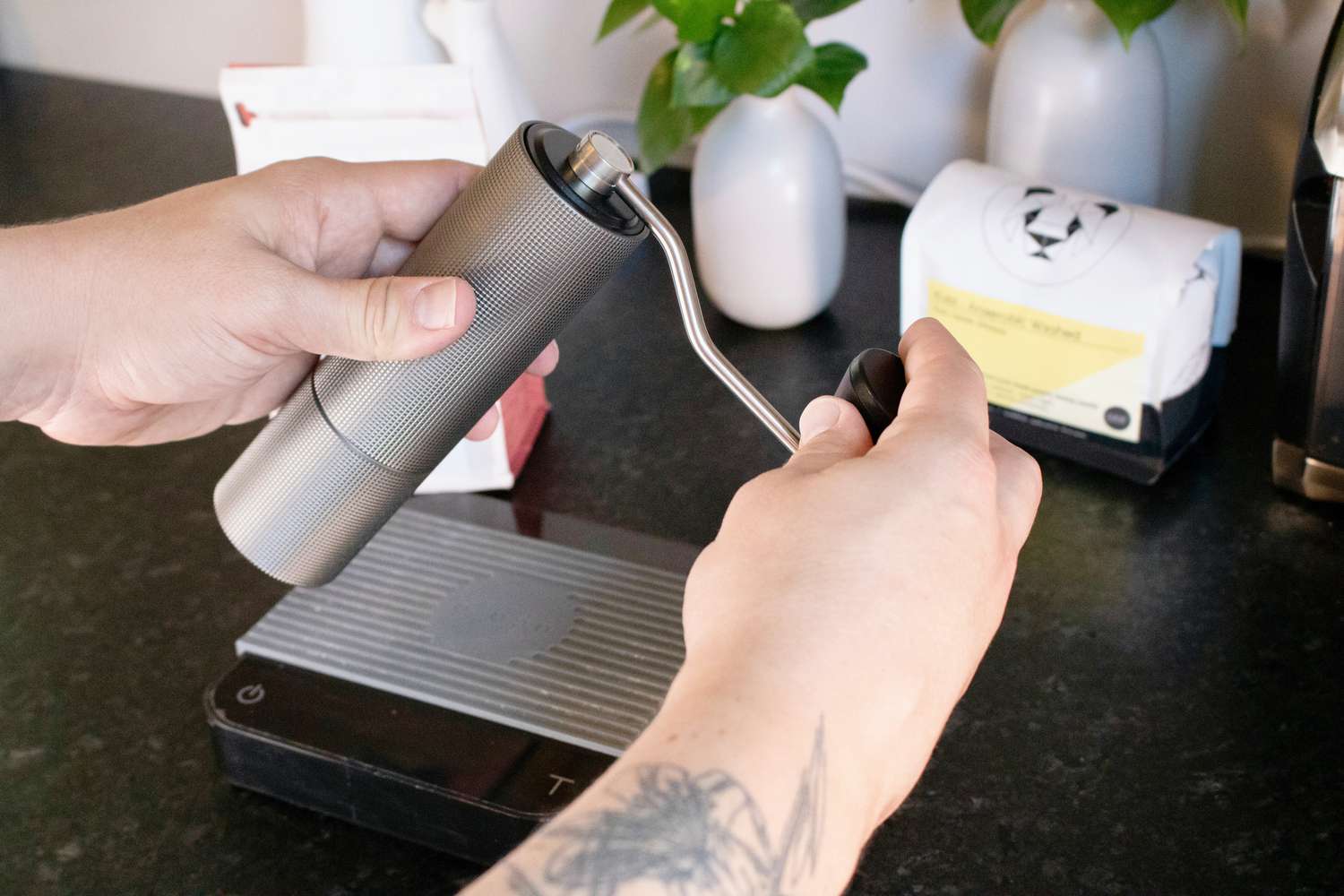 a handheld grinder is being held and cranked