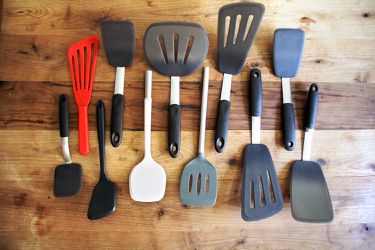 the lineup of spatulas on a wooden cutting board