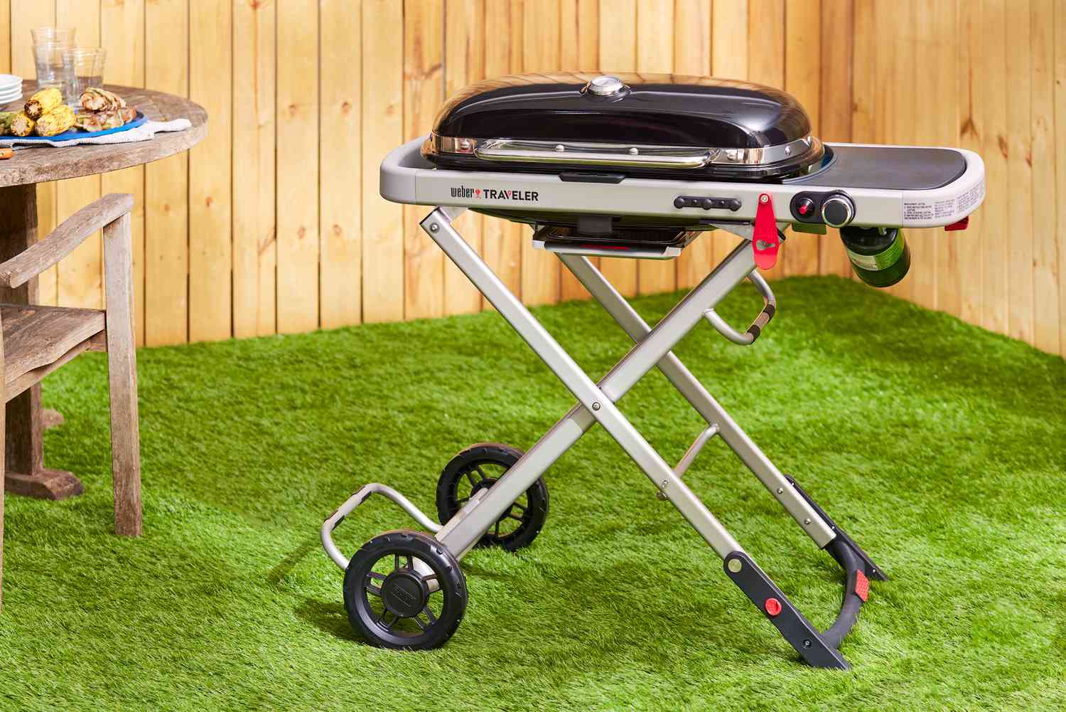 a portable gas grill set up in a backyard