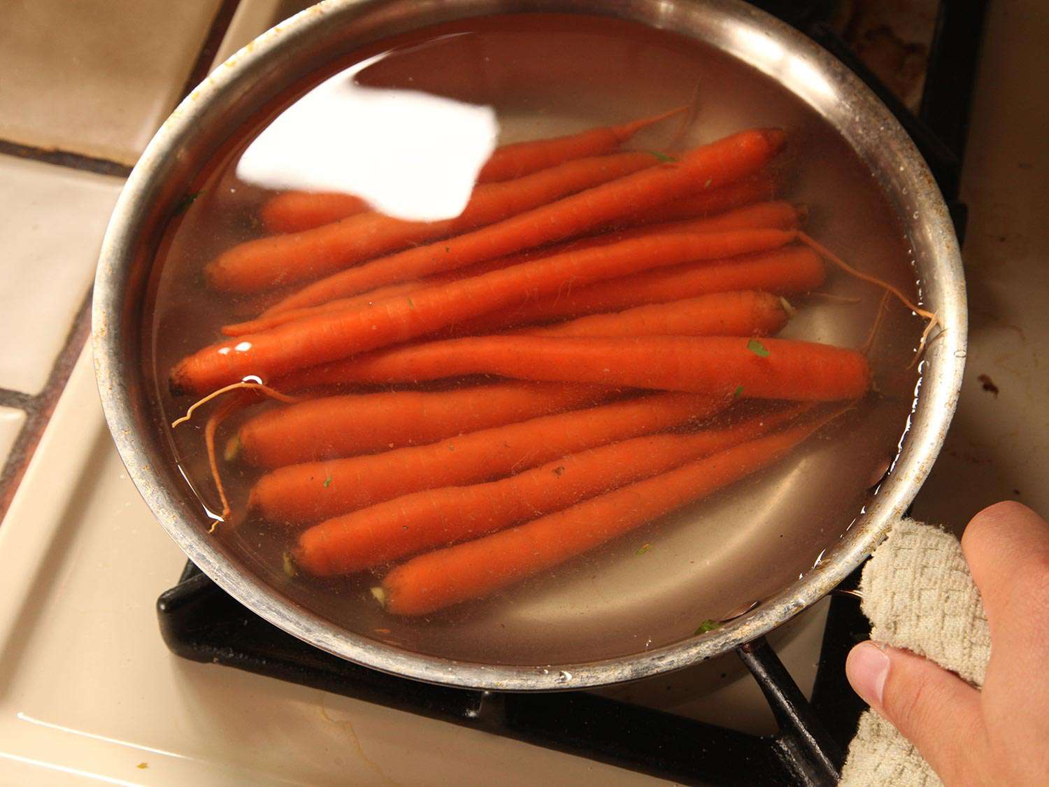 在煎锅中加水覆盖整个胡萝卜。