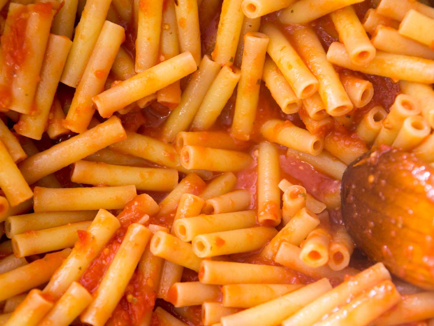 近距离观察煮熟的意大利面被涂上番茄酱。