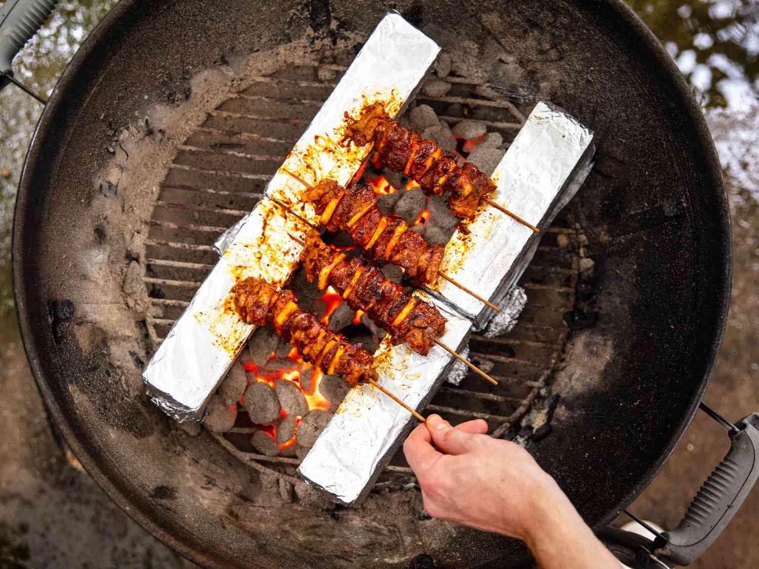 Overhead shot of al pastor skewers grilled using the skewer set-up for a kettle grill