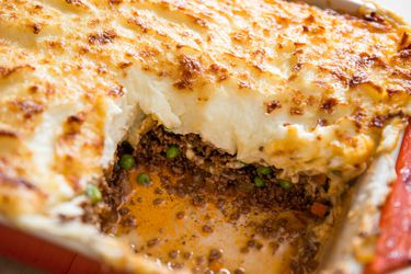 Shepherd's Pie in red casserole dish with one square portion removed