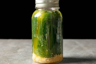 一罐密尔沃基莳萝冰箱泡菜，底部有大蒜。gydF4y2Ba