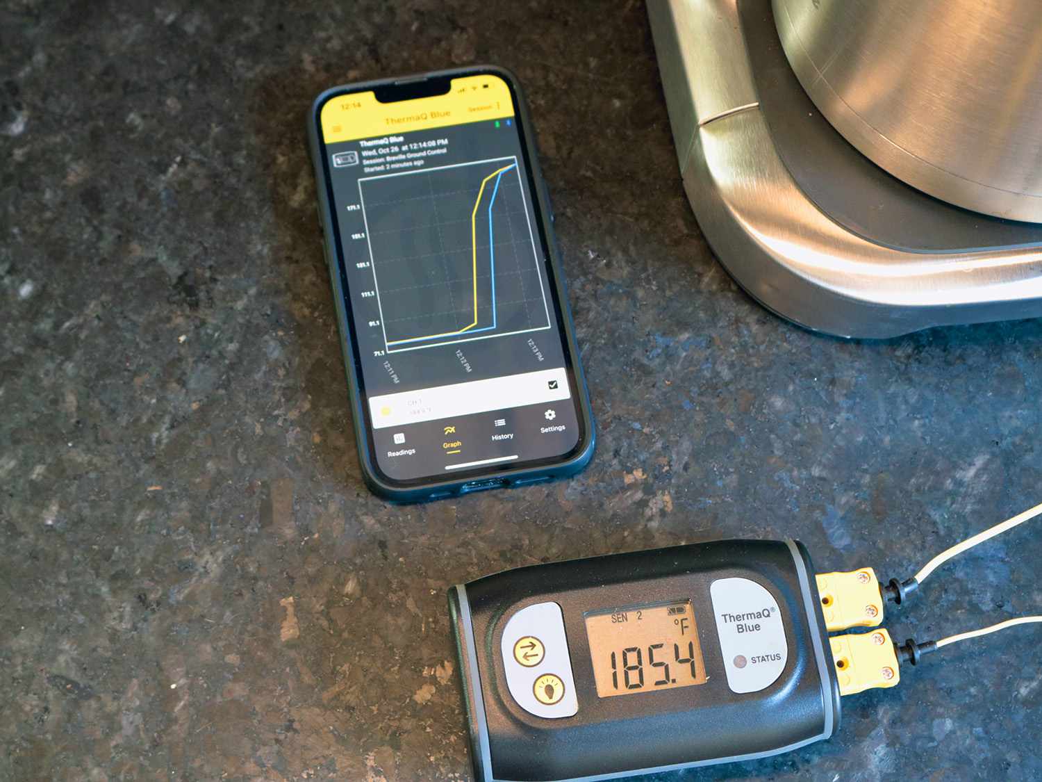 一个热探头显示温度为185ÂºF，旁边是手机上显示温度上升的应用程序