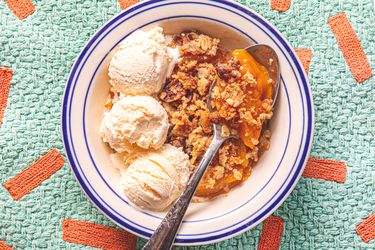 Overhead view of peach crisp served with ice cream
