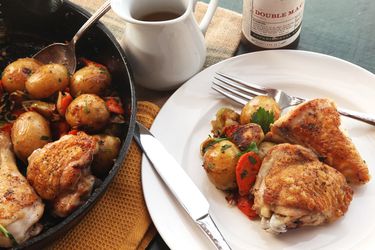 A skillet and plateful of pan-roasted chicken and vegetables with Dijon jus.