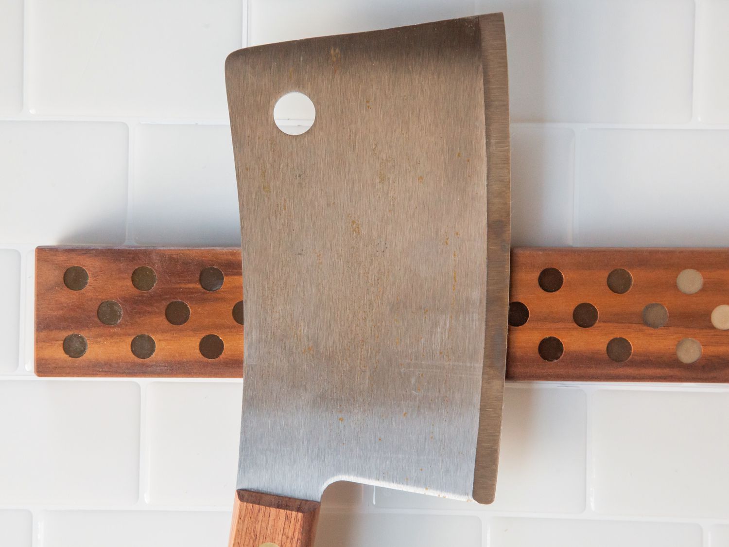 A closeup shot of a cleaver on a wooden knife strip