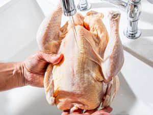 Overhead view of washing a chicken in the sink