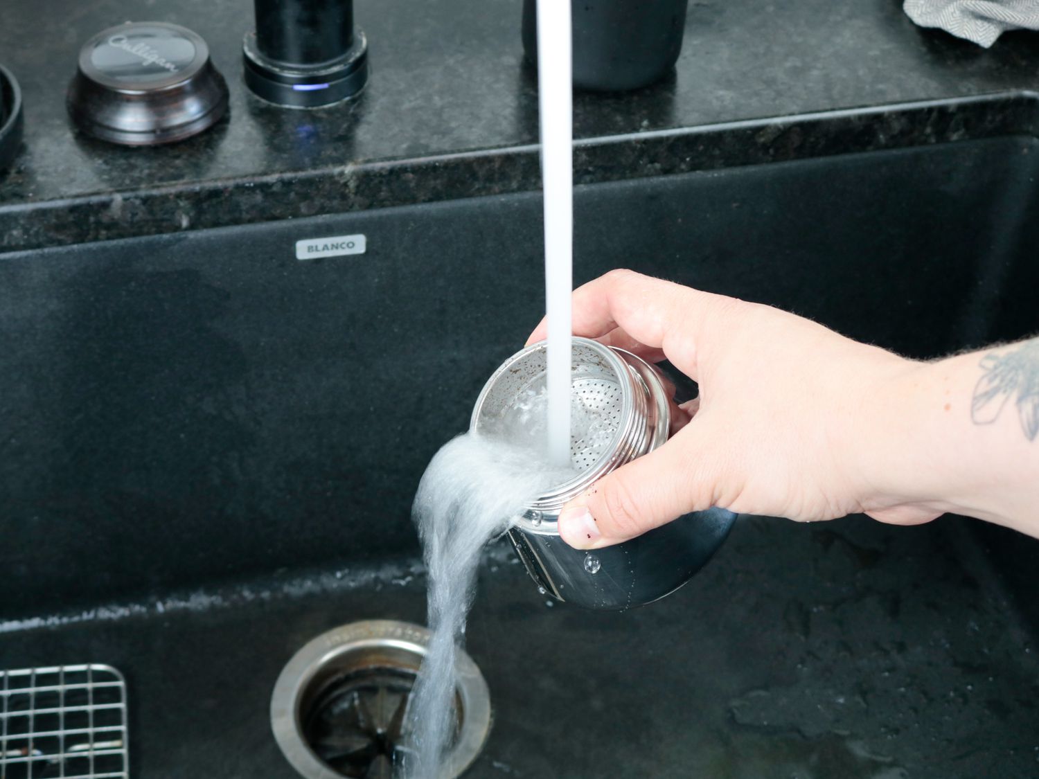 a moka pot being rinsed out