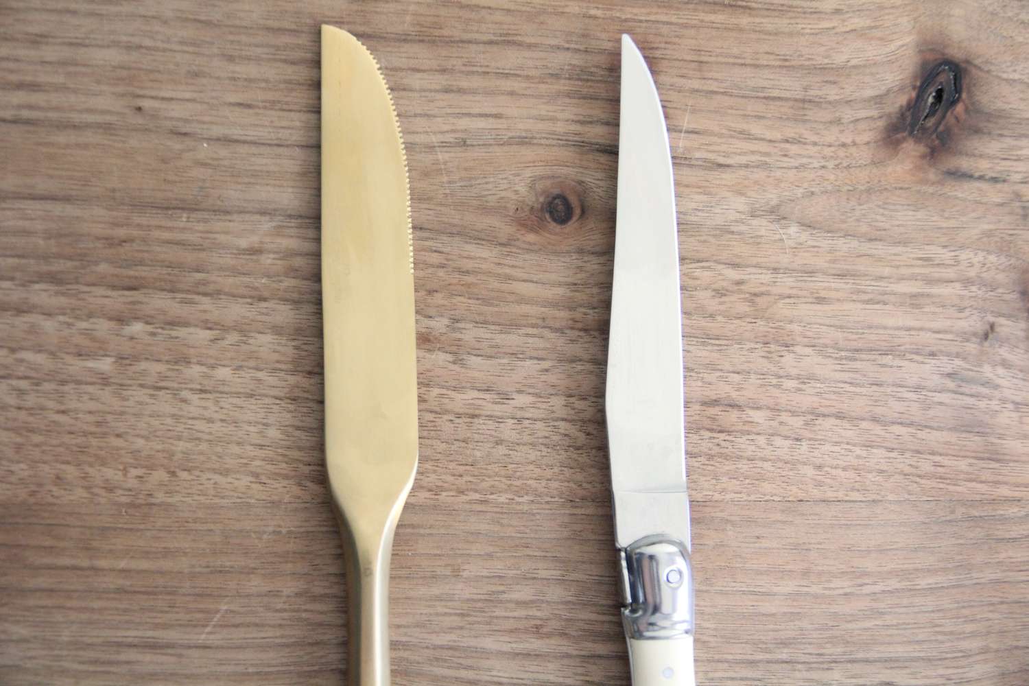 两把刀并排放在一个木制的表面上
