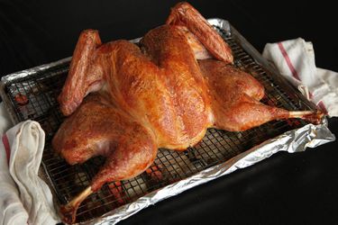 Spatchcocked turkey on a wire rack set in a rimmed baking sheet