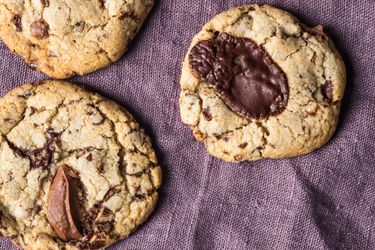 Quick and easy chocolate chip cookies on a purple linen.