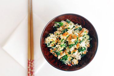 A bowl of fried rice with bok choy, kale, and crisp fried garlic.