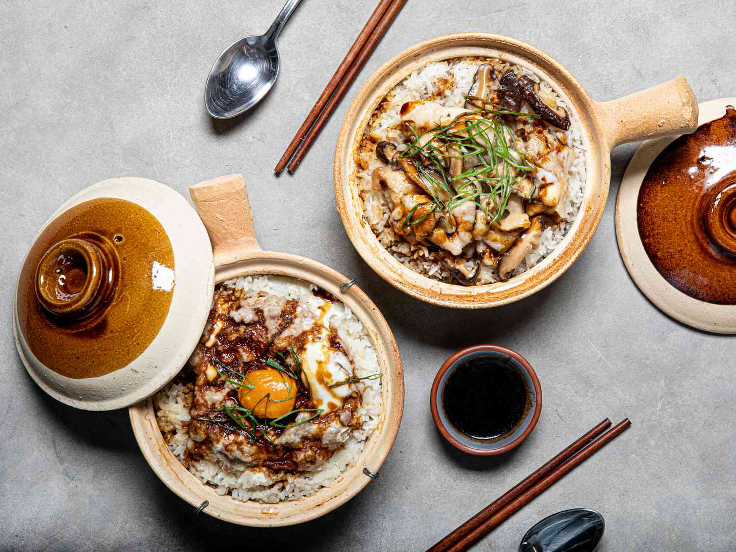 Two pots of Cantonese clay pot rice: one with Chinese meatloaf and another with velveted chicken.