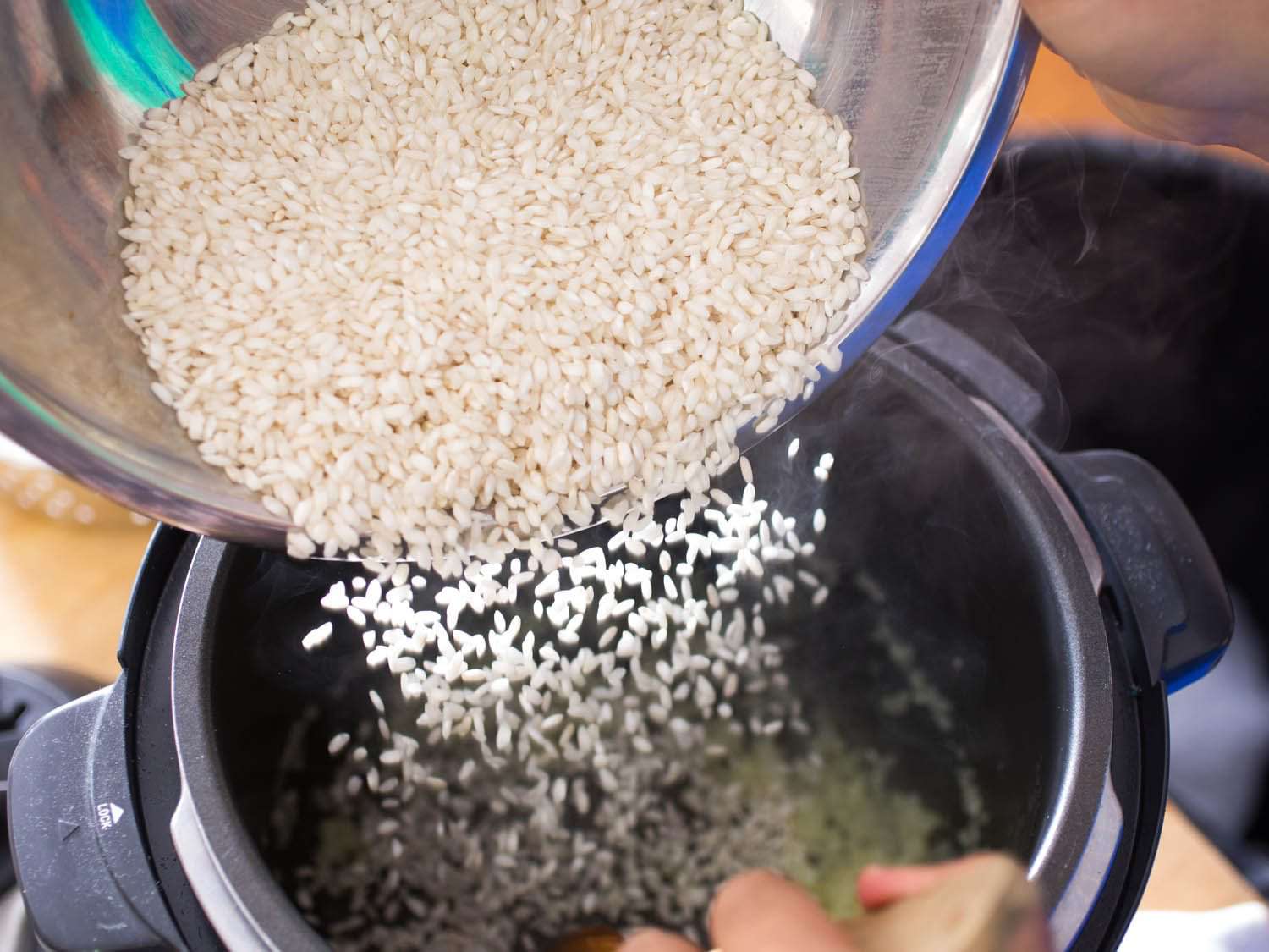 rice being poured into pressure cooker for risotto