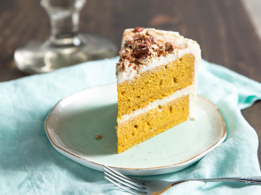 A slice of frosted pumpkin layer cake.