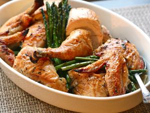 Easy roast chicken with asparagus and leeks, arranged in a deep serving platter.