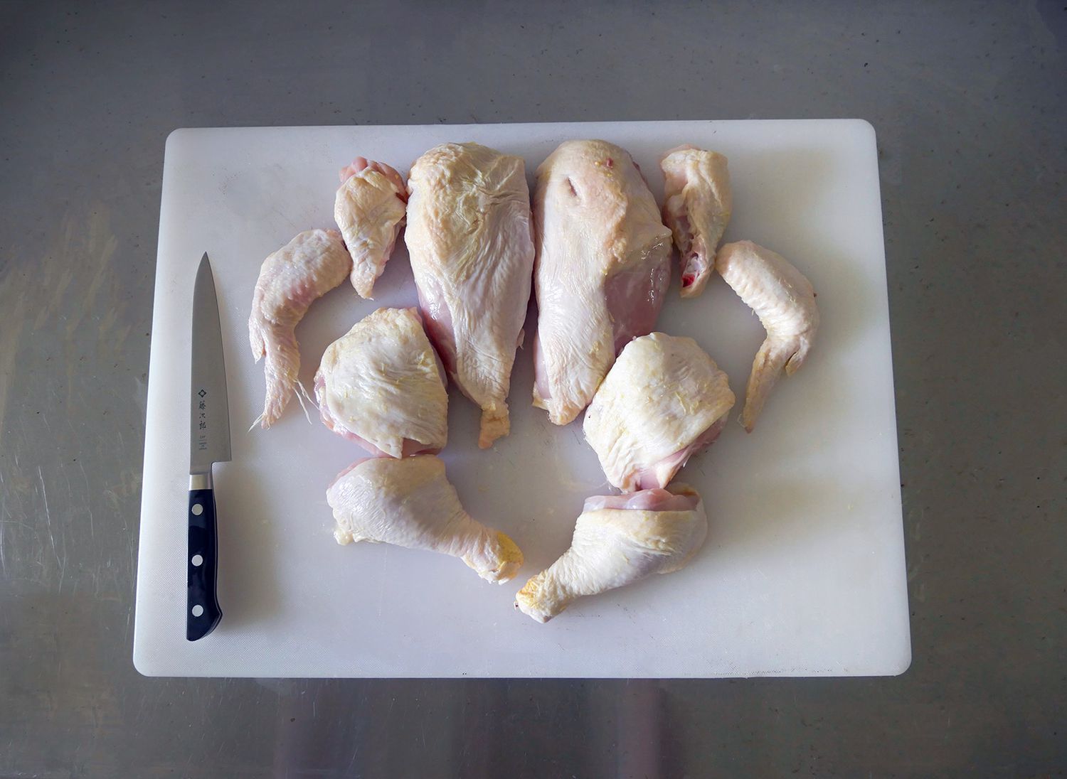 a whole chicken cut up on a cutting board