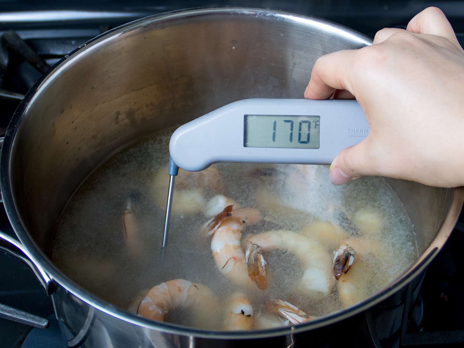 温度计在煮熟的虾锅中显示170华氏度的温度。