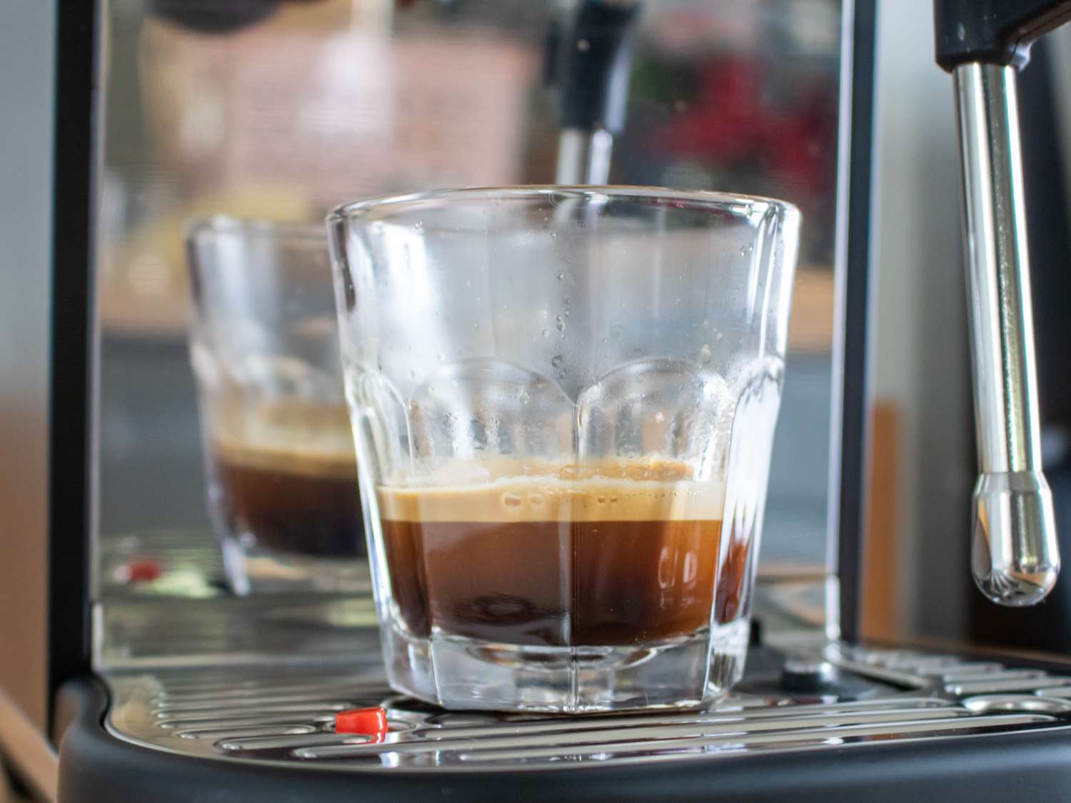 a clear glass with a double espresso shot from the Breville Bambino Plus espresso machine