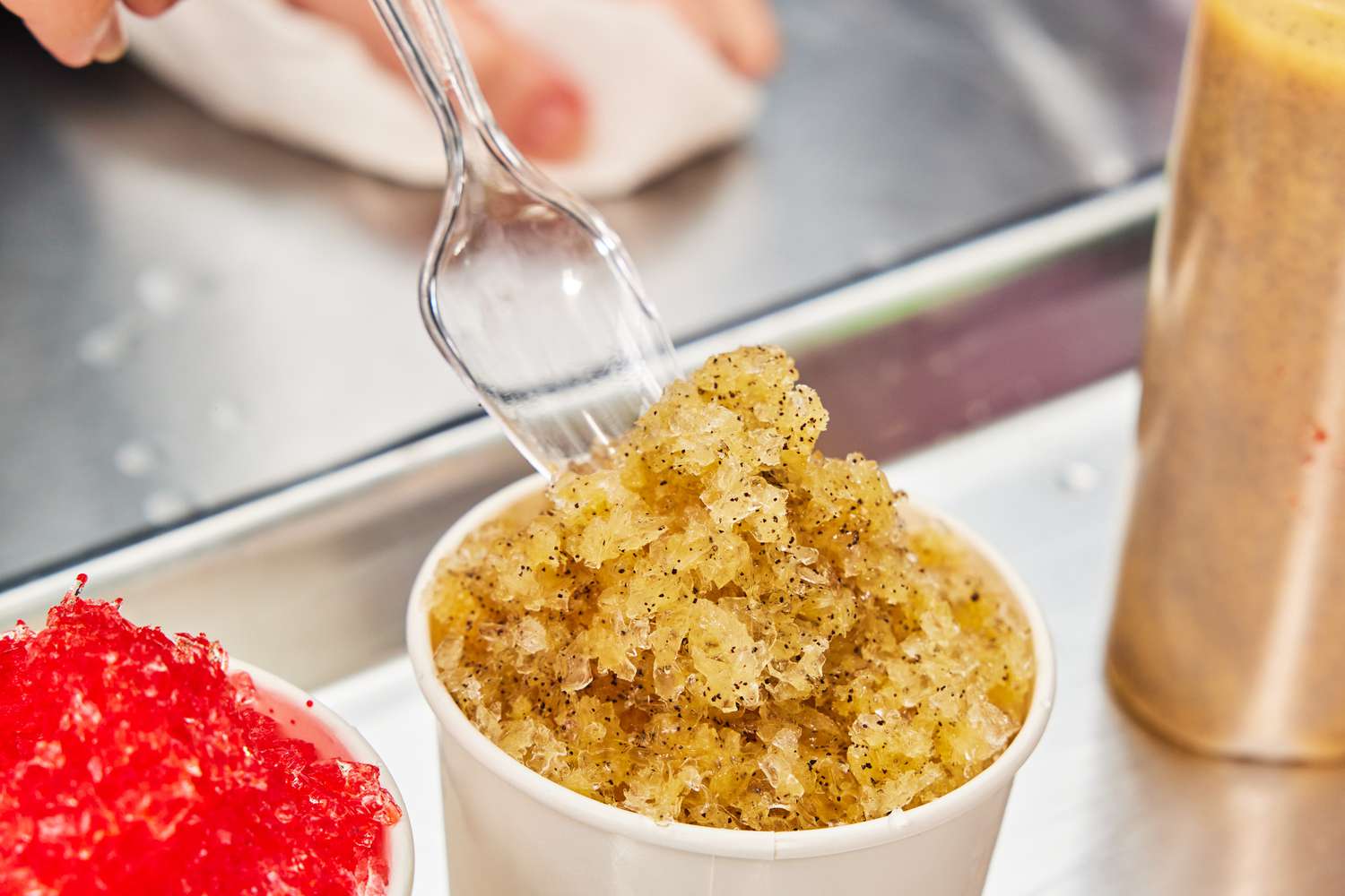 a spoon scooping shaved ice out of a bowl