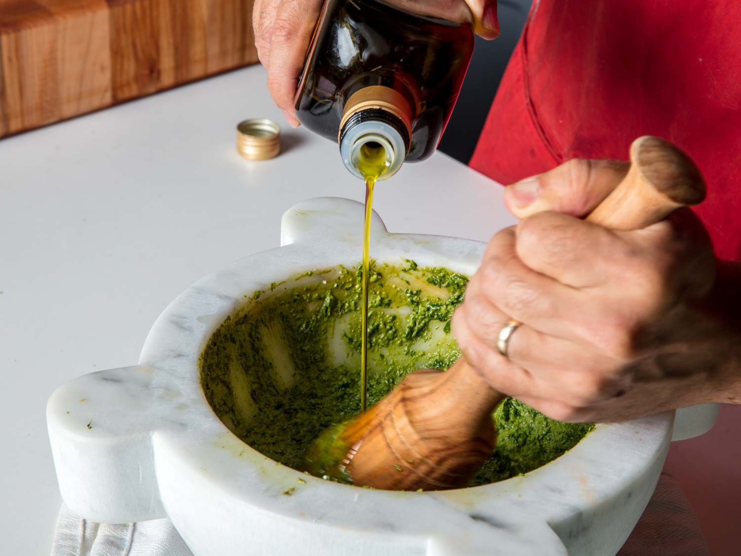 将橄榄油滴入罗勒、松子和蒜蓉中，放入大理石臼中制成传统的香蒜沙司。gydF4y2Ba