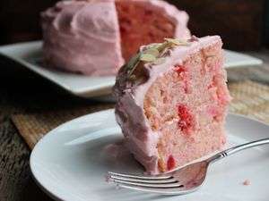 slice of pink cake with cherries