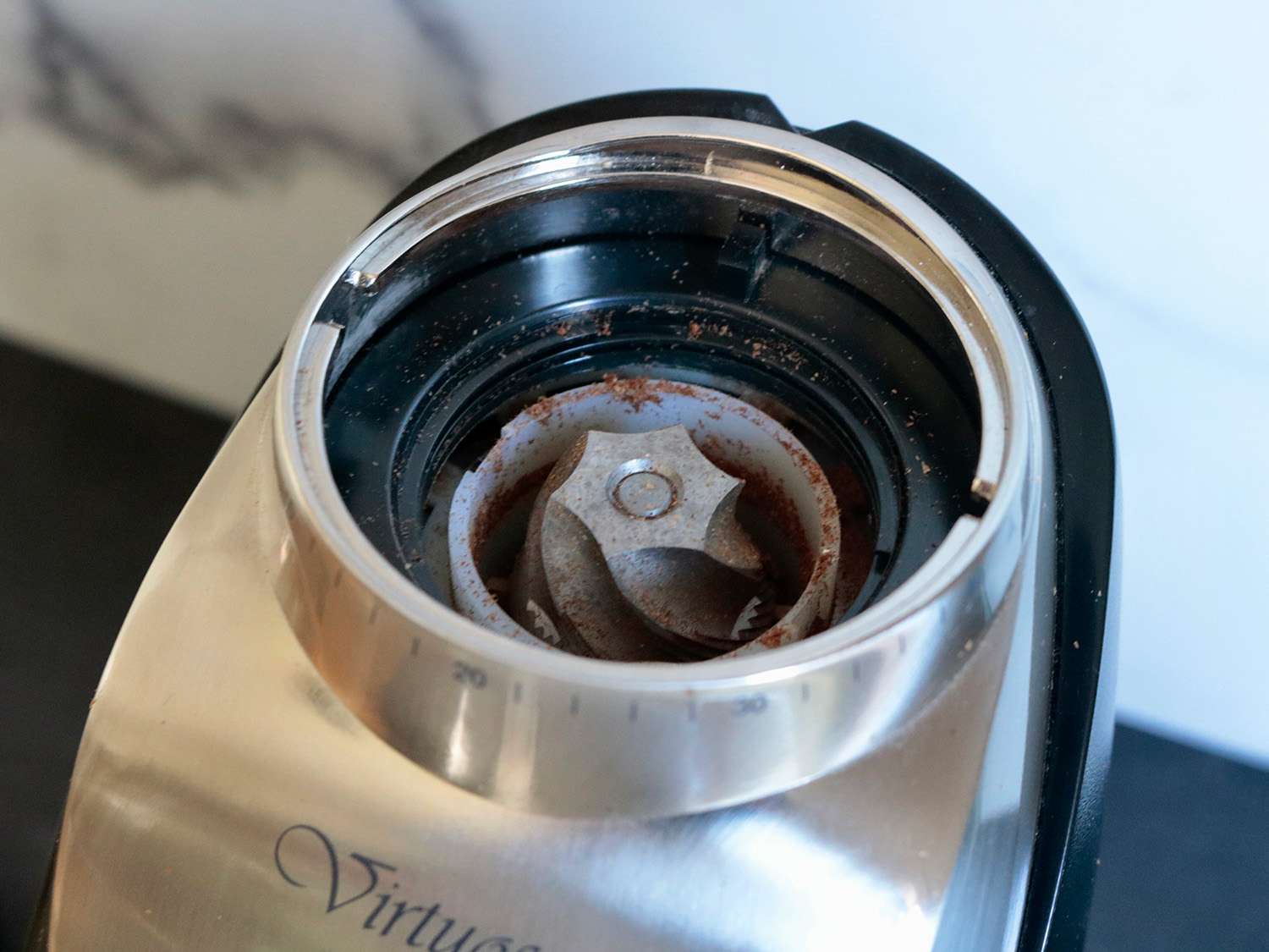 一个开着的咖啡研磨机的特写，展示了里面的毛刺