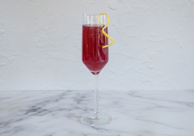 Pomegranate rouge cocktail garnished with a lemon twist.