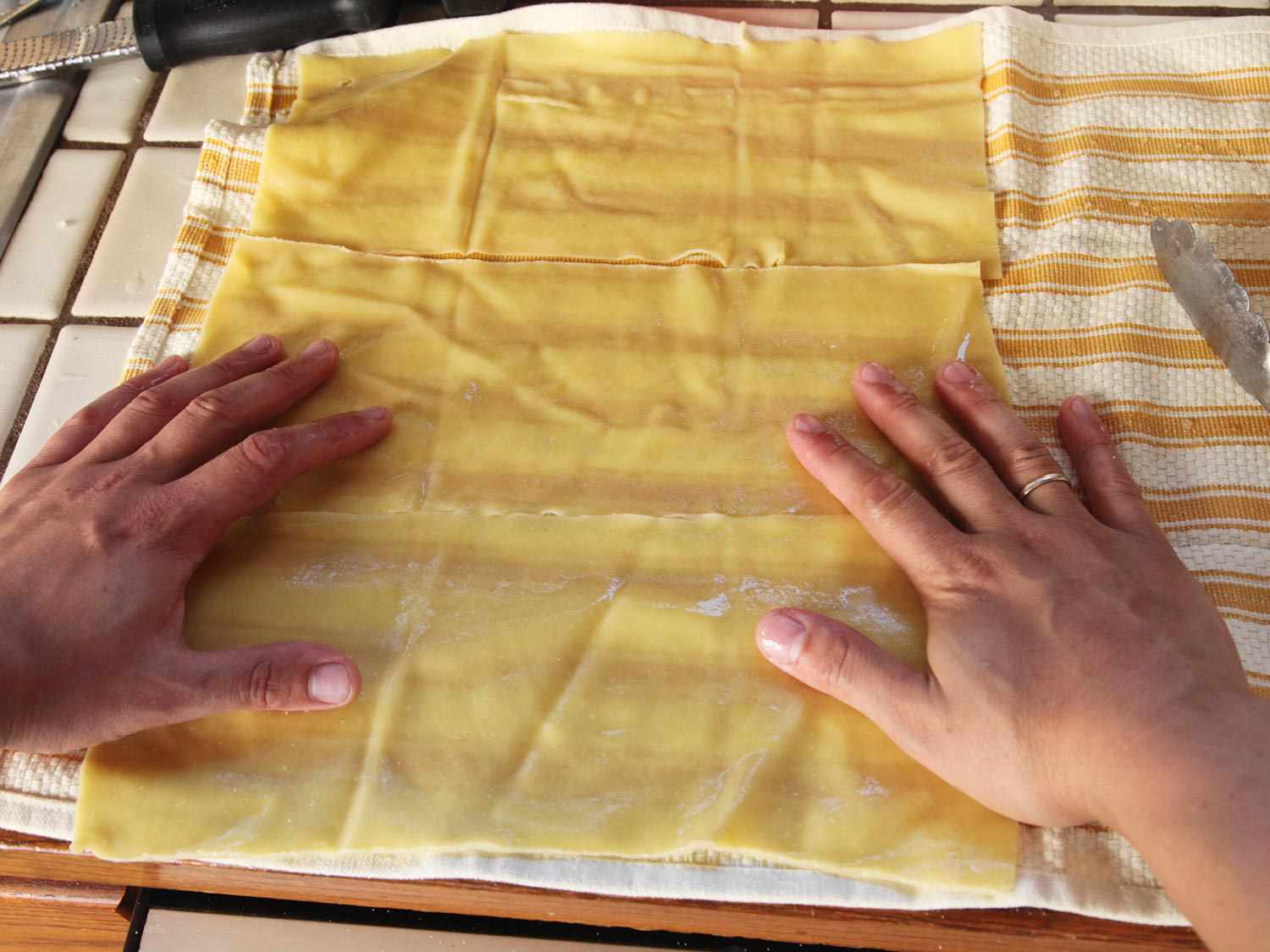 Drying rinsed pasta sheets on dish towels