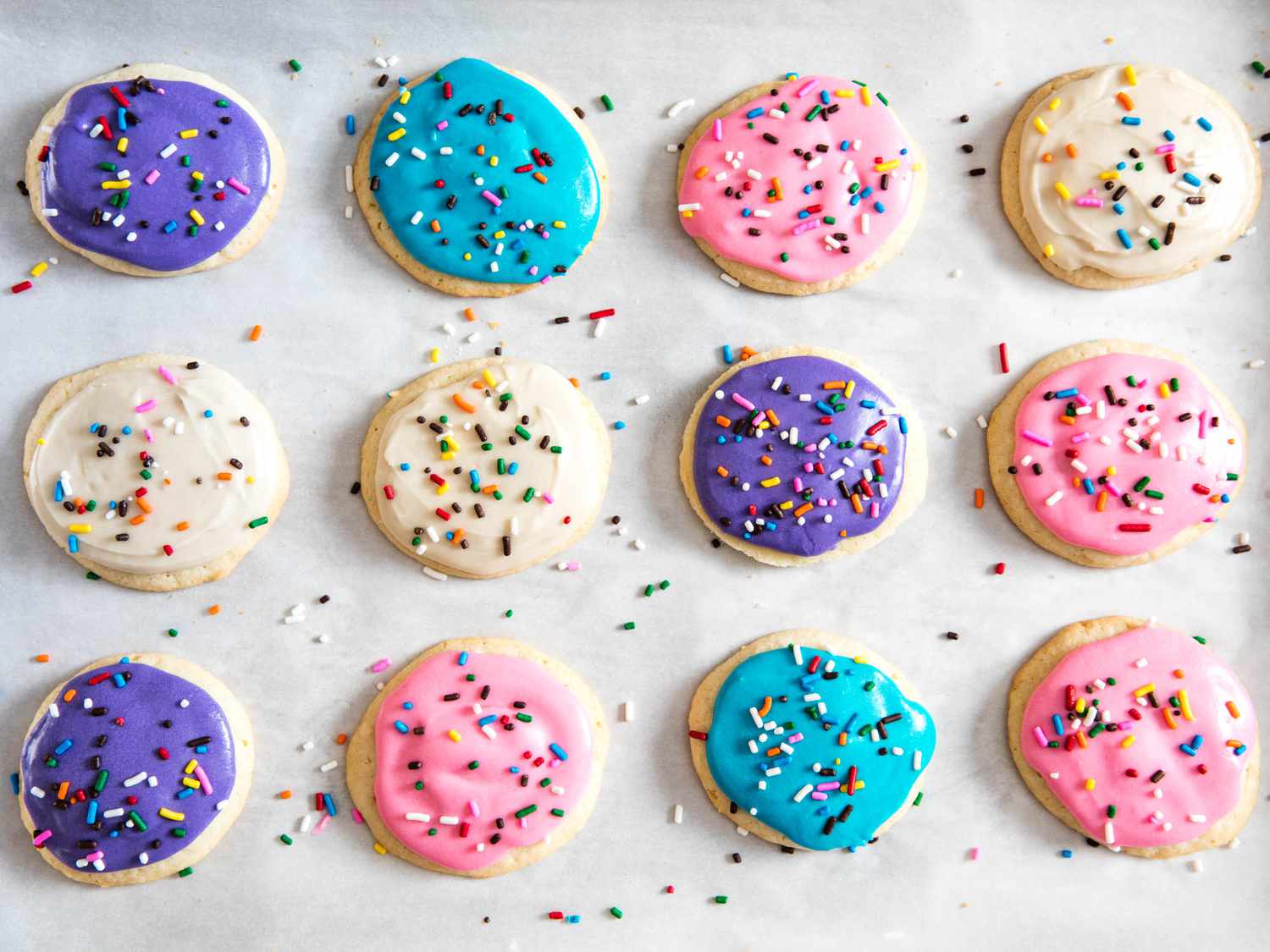 Overhead shot of colorfully frosted sugar cookies covered in sprinkles.