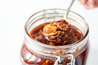 Jar of homemade chili crisp with a spoonful being removed