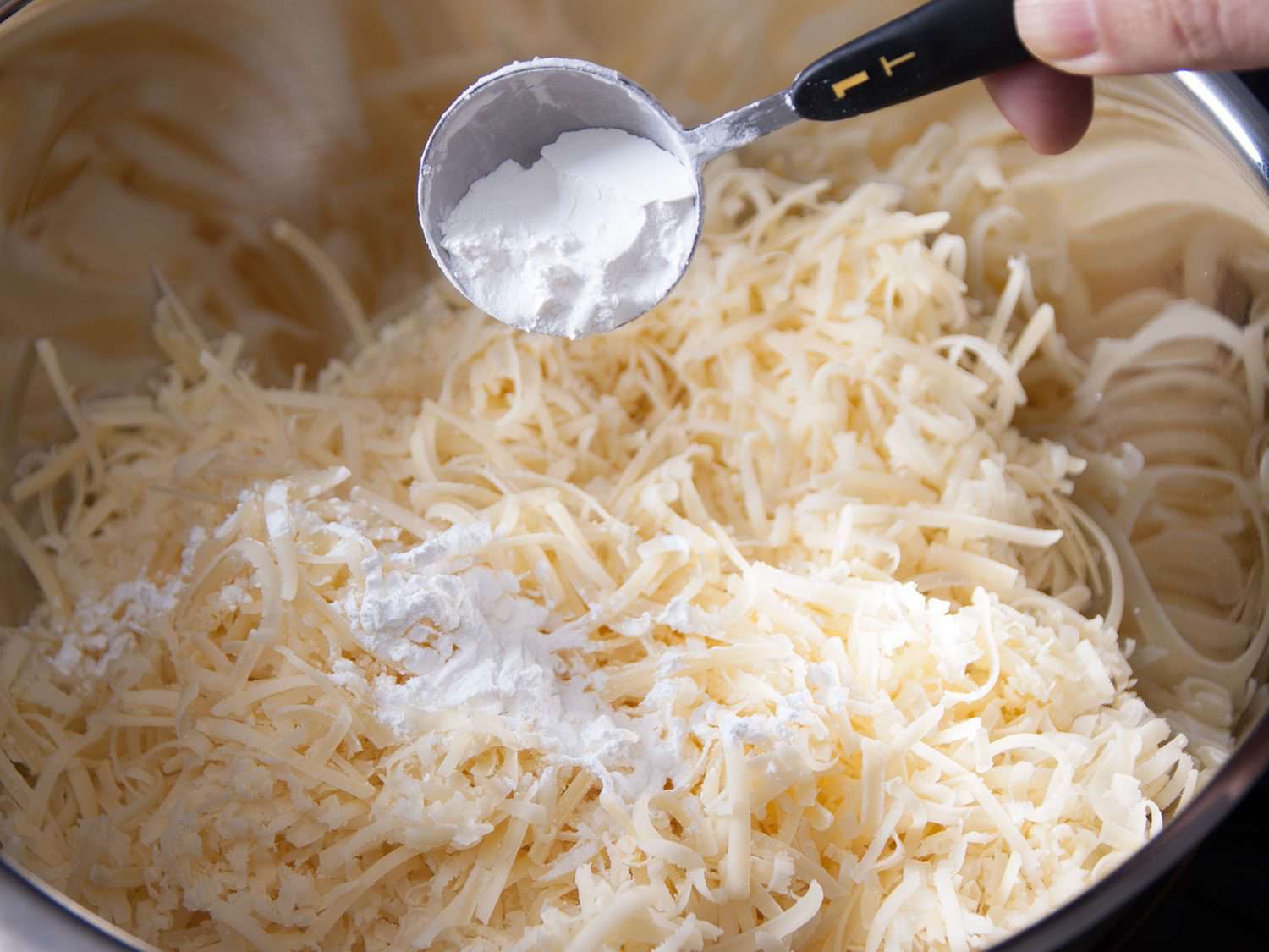 在一碗磨碎的奶酪中加入玉米淀粉。