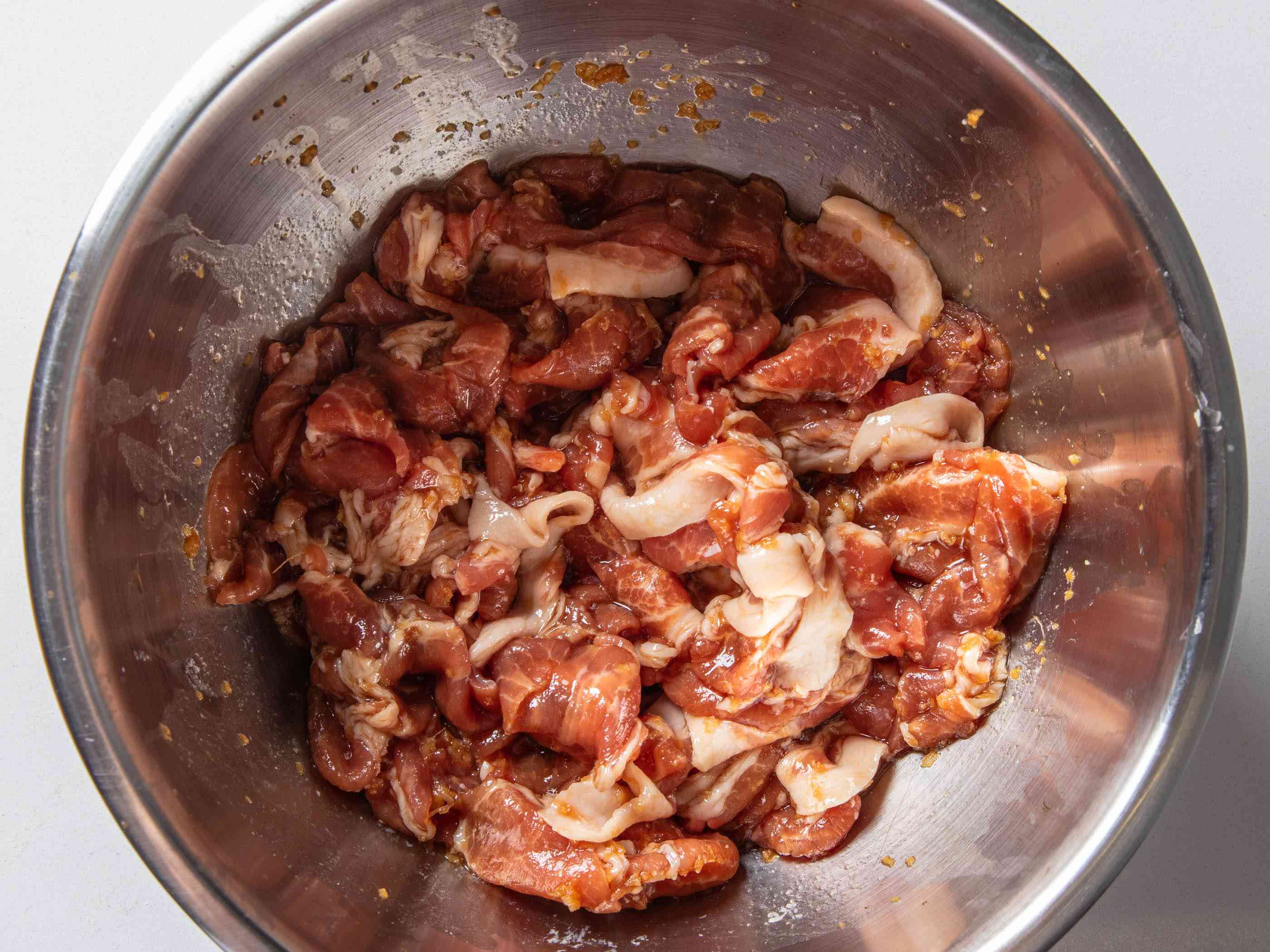 切成薄片的猪肉，用酱油、米酒、清酒和蒜末腌制