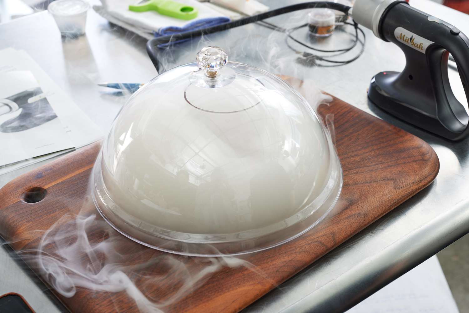 A large cloche containing the smoke from a smoking gun