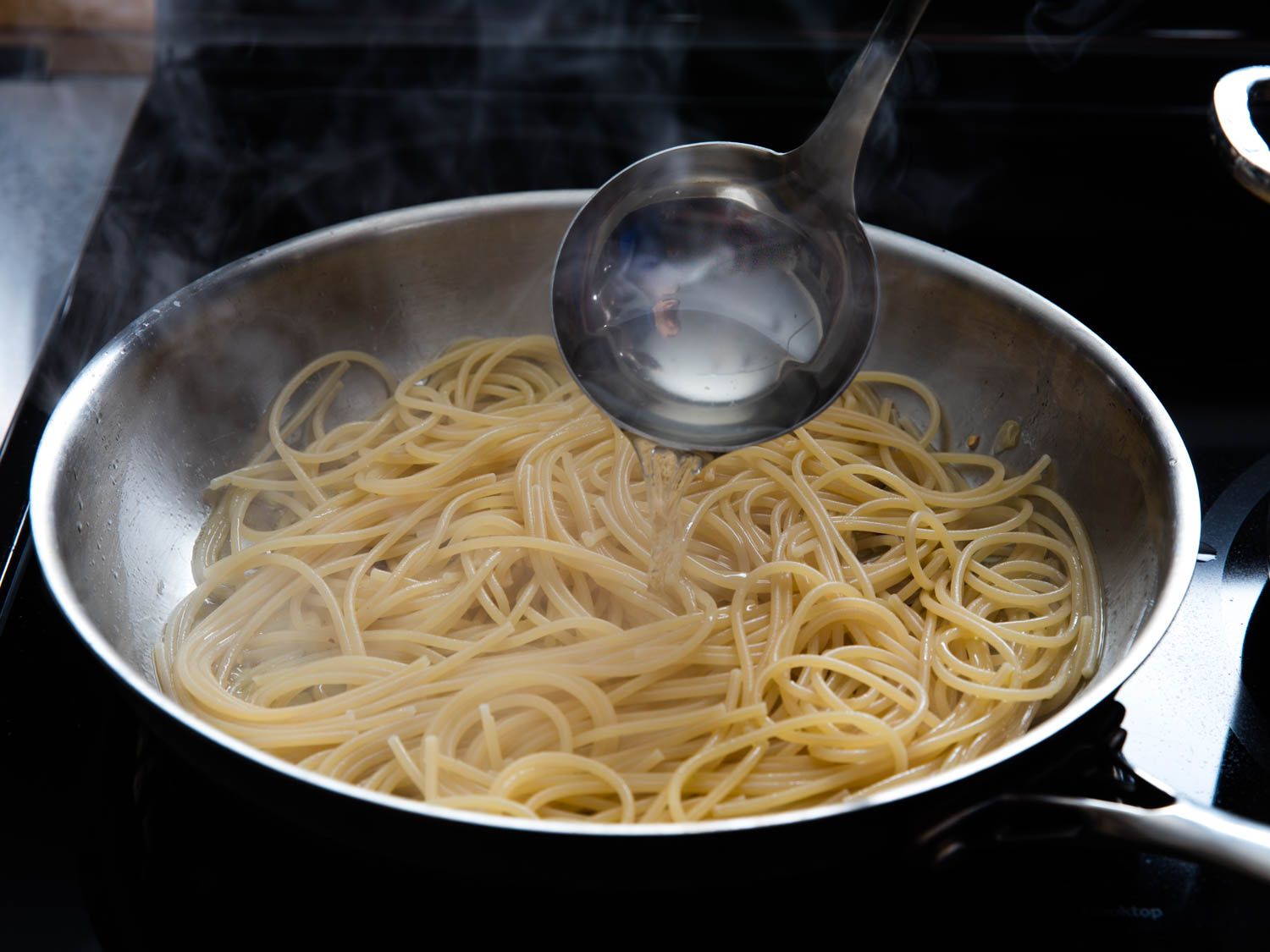 将煮好的意大利面、大蒜和橄榄油淋上一勺意大利面水gydF4y2Ba