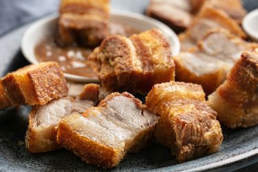 A close up of lechon kawali (Filipino crispy pork belly) on a plate