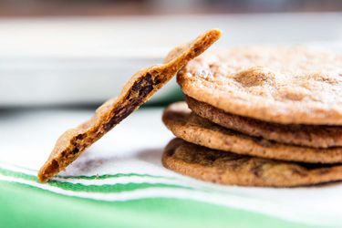 A stack of thin, crispy Tate's style chocolate chip cookies