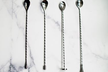 four bar spoons on a marble countertop