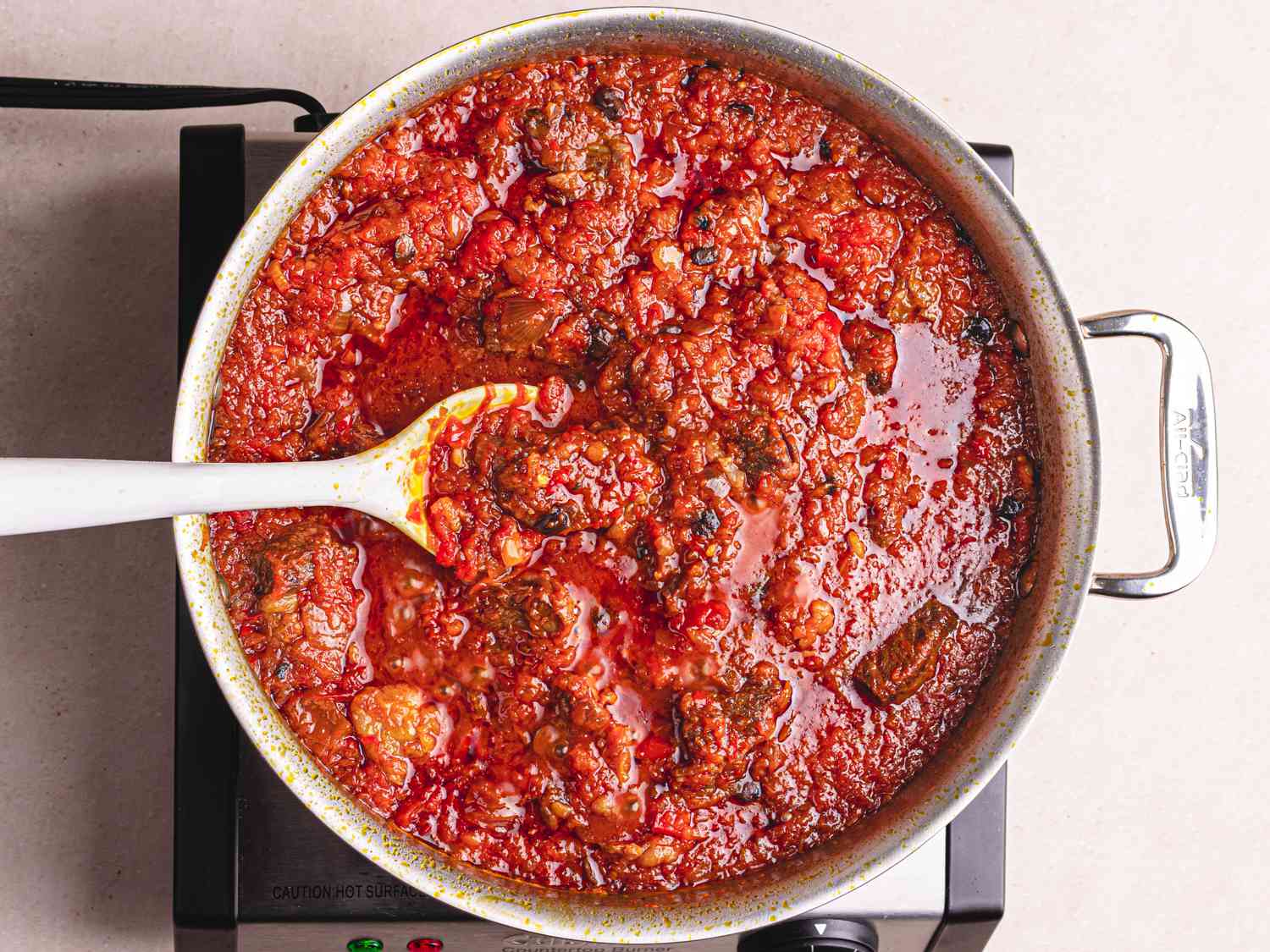 Overhead view of thickening stew with tomato mixture added in