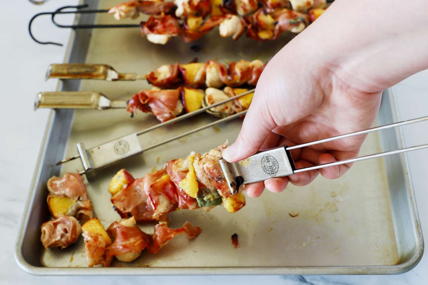 a closeup look at a hand removing food from a skewer