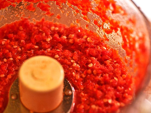 Finely chopped chiles in the bowl of a food processor.