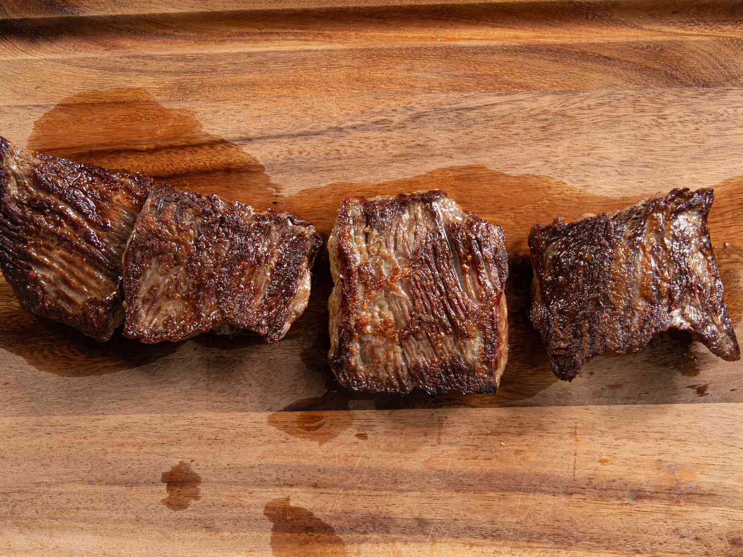 Three cuts of meat resting on a cutting board.