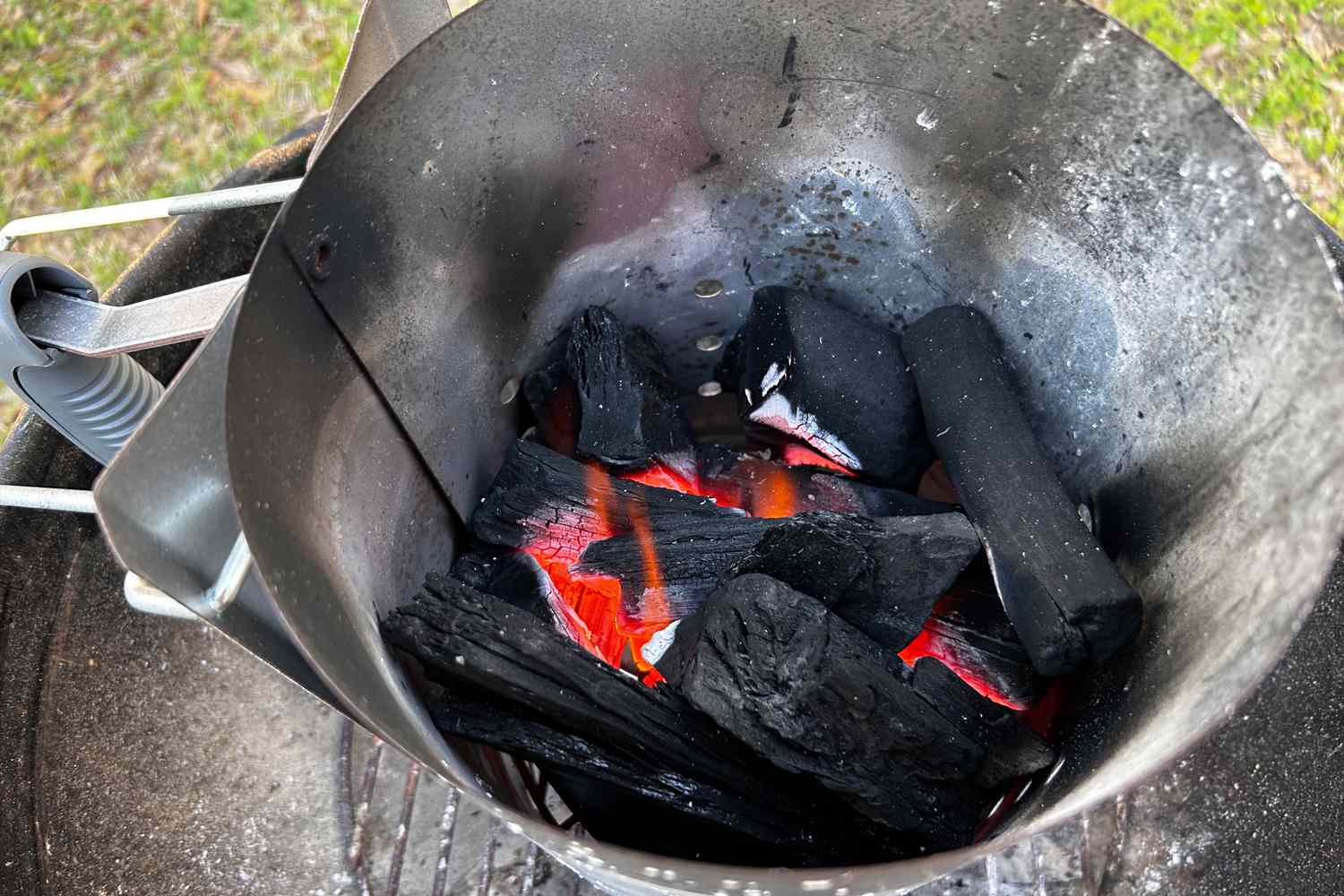 a closeup look at lump charcoal in a chimney starter