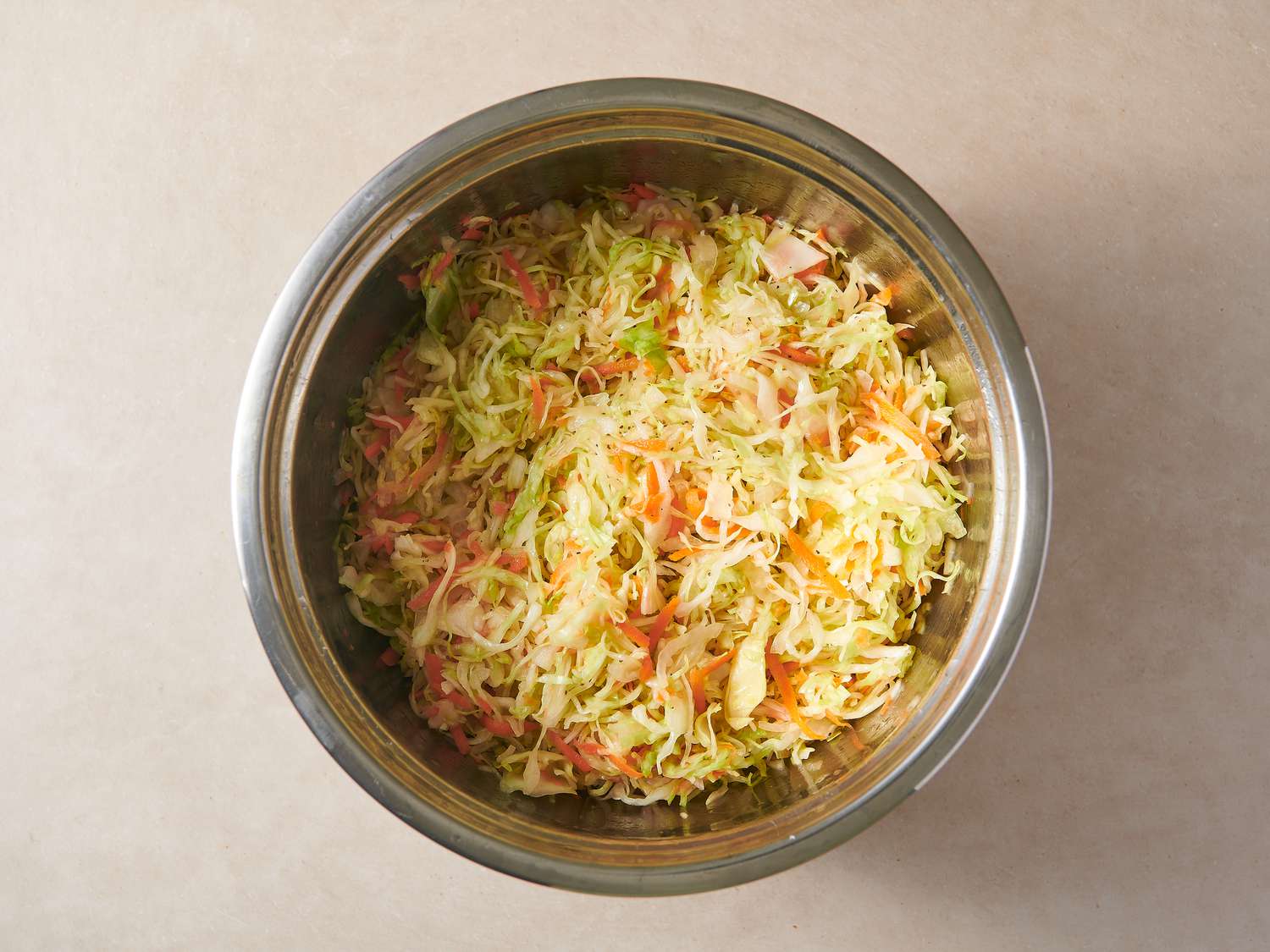 Vegetables coated in dressing inside large bowl