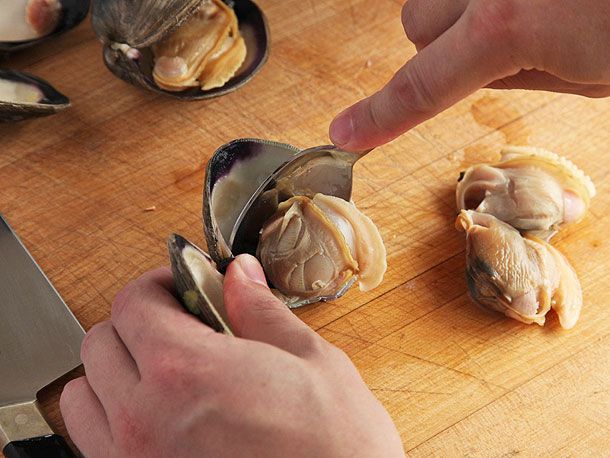 用勺子将煮熟的蛤蜊从壳中取出。